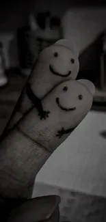 Adorable finger art with smiley faces on two fingers, black and white theme.