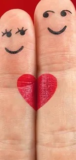 Two fingers with drawn smiles and a heart on a red background.