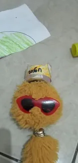 Fluffy toy with red sunglasses and a playful expression.