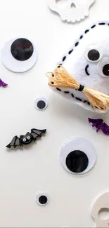 Cute ghost and Halloween decor with googly eyes and bats on a white background.