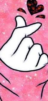 Hand gesture with a heart on a pink, sparkling background wallpaper