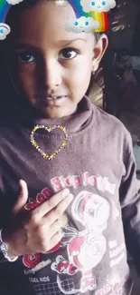 Cute child wearing a brown sweater with rainbow and cloud effects.