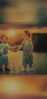 Two children holding hands at sunset.