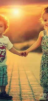 Two young kids smile holding hands in sunset glow.