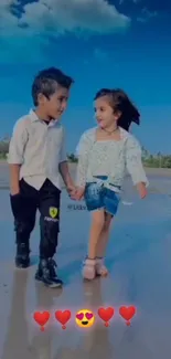 Two kids smiling, holding hands on a sunny beach with blue skies.