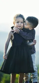 Two adorable kids embracing in an outdoor setting.