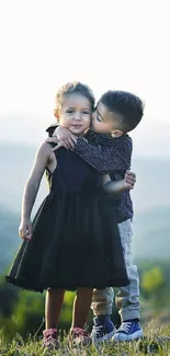 Two children hugging in a scenic, sunlit nature backdrop.