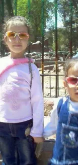 Two young girls in sunglasses enjoying a sunny day.