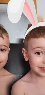 Twin boys wearing bunny ears with playful expressions.