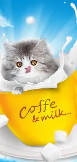 Cute kitten sitting in a yellow coffee cup with milk splash and blue sky background.