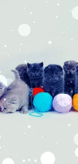 Adorable kittens with colorful yarn balls as a phone wallpaper.