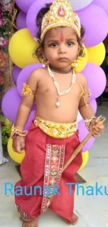 Young child in Krishna costume with balloons.