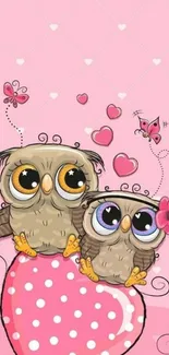 Cute owls sitting on a pink heart with butterflies and polka dots background.