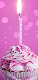 Pink cupcake with candle on pink background.