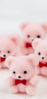 Fluffy pink teddy bears with red bows on white background.