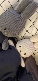 Cute plush bunnies resting on a cozy bed.