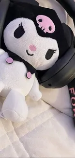 Plush toy with headphones and book on quilt.