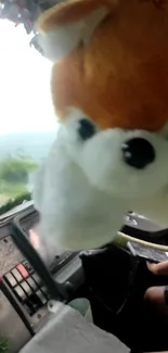 A cute plush toy hanging in a vehicle's interior, creating a playful scene.