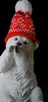 Cute polar bear with a red knitted hat on a dark background.