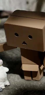 Cardboard robot with cat figurines in playful scene.