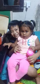 Siblings relaxing on a colorful couch.