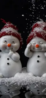 Two cute snowman figurines with red hats and snowflakes on a dark background.