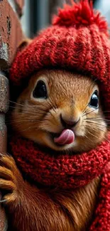 Squirrel wearing a red hat and scarf next to a brick wall.