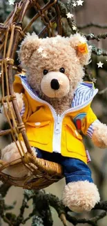 Teddy bear in yellow jacket on swing in nature.