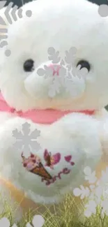 Cute teddy bear with pink scarf on grass with snowflake overlay.