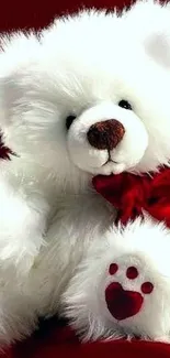 Adorable white teddy bear with red bow on deep red background.