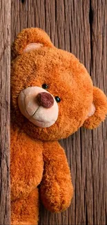 Adorable teddy bear peeking around a rustic wooden texture.