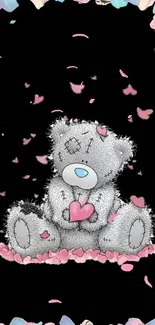 Cute teddy bear holding a pink heart with pastel petals border.