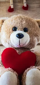 Cute teddy bear with red heart on wooden backdrop.