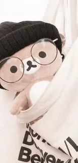 Cute teddy in glasses and beanie peeking from a canvas bag.