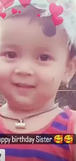 Cute toddler with birthday hearts, smiling.