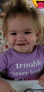 Cute toddler with playful hair and emoji face.