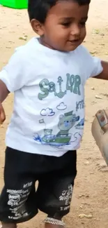 Cute toddler wearing sailor t-shirt, smiling outdoors.