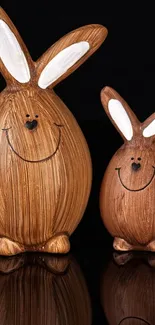 Two smiling wooden bunny figures on a black background.