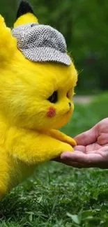 Cute yellow creature with hat in nature, touching a hand.