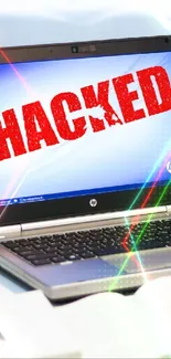 Laptop showing 'Hacked' alert on screen, conveying a cyber security theme.