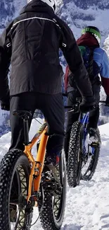 Cyclists biking through snowy mountain trails, embracing winter adventure.