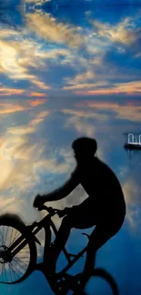 Silhouette of cyclist against a dreamy sunset sky with calm waters below.