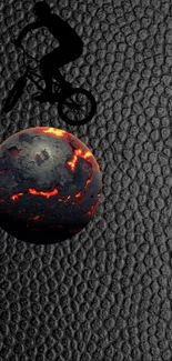 Cyclist silhouette on a glowing fiery sphere with a textured dark background.