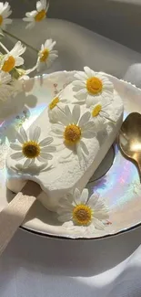 Daisy-decorated ice cream with gold spoon on elegant plate.