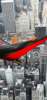 Person in hammock high above city skyscrapers.