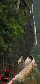 Car navigates narrow cliffside road in lush greenery.