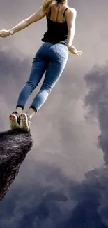 Woman stands on cliff edge under a cloudy sky, embodying freedom and adventure.