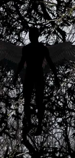 Silhouette of an angel with wings against a dark tangled background.