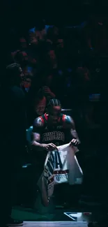 Moody image of basketball player in focus with dramatic lighting.