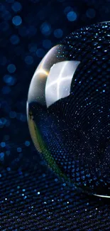 Abstract navy blue wallpaper with glass sphere and bokeh effect.